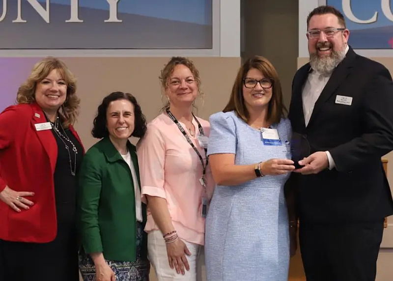 Pictured left to right: Bucks IU’s Rebecca Roberts-Malamis, Esq., Deputy Executive Director and In-House Legal Counsel; Dr. Rachel Holler, Assistant Executive Director, Dr. Jen Hertwig, Assistant to the Executive Director for Operations; Kim Permar, BCHIP Executive Director handing the award to Dr. Mark Hoffman, Bucks IU Executive Director. (Credit: BCHIP)