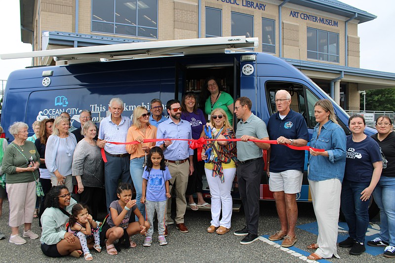 Library Director Karen Mahar uses an oversized pair of scissors to cut the ribbon. (Photo courtesy of Ocean City Regional Chamber of Commerce)