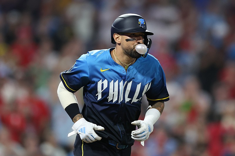 May 16, 2025; Philadelphia, Pennsylvania, USA; Philadelphia Phillies outfielder Nick Castellanos (8) blows a bubble while taking first base after being hit by a pitch with the bases loaded during the seventh inning against the Pittsburgh Pirates at Citizens Bank Park. Mandatory Credit: Bill Streicher-Imagn Images