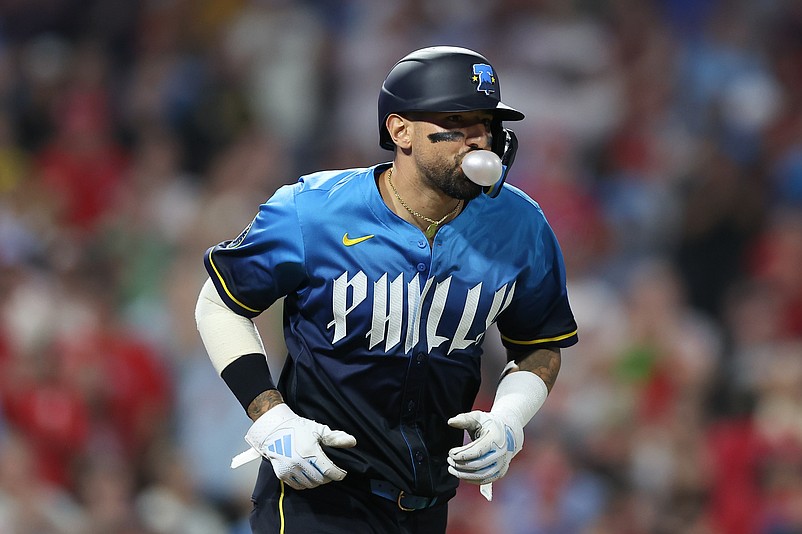 May 16, 2025; Philadelphia, Pennsylvania, USA; Philadelphia Phillies outfielder Nick Castellanos (8) blows a bubble while taking first base after being hit by a pitch with the bases loaded during the seventh inning against the Pittsburgh Pirates at Citizens Bank Park. Mandatory Credit: Bill Streicher-Imagn Images