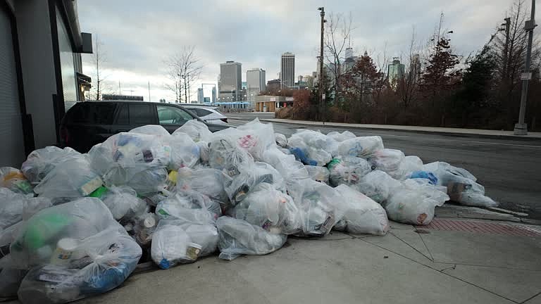 A large pile of trash bags sits curbside in New York City. (Credit: SK/Getty Images)