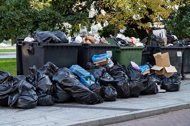 Huge garbage piles next to the dumpster. (Credit: IStock by Getty Images)