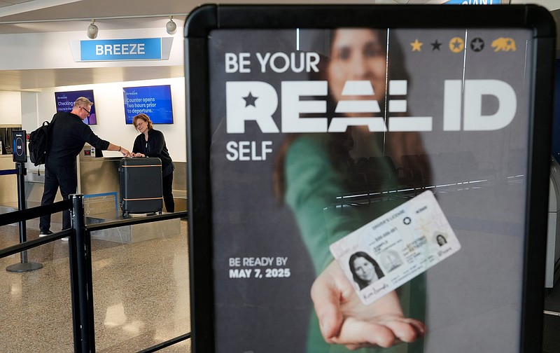 Signage reminding travelers to be ready with their REAL ID-compliant driverâ€™s license stands near the Breeze Airways counter as Ron Oâ€™Neil of St. Petersburg, Florida, checks his bag at Akron-Canton Airport on Wednesday, May 7, 2025, in Green, Ohio.