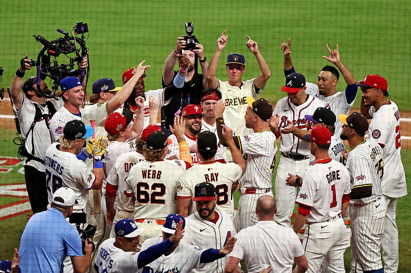 Jul 15, 2025; Cumberland, Georgia, USA;  National League designated hitter Kyle Schwarber (12) of the Philadelphia Phillies celebrates with his teammates after hitting in the swing off after the 2025 MLB All Star Game ended in a tie at Truist Park. Mandatory Credit: Jordan Godfree-Imagn Images