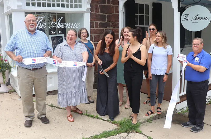 Owner Suzanne Landis cuts the ribbon at the grand opening celebration of The Avenue Salon in Souderton.