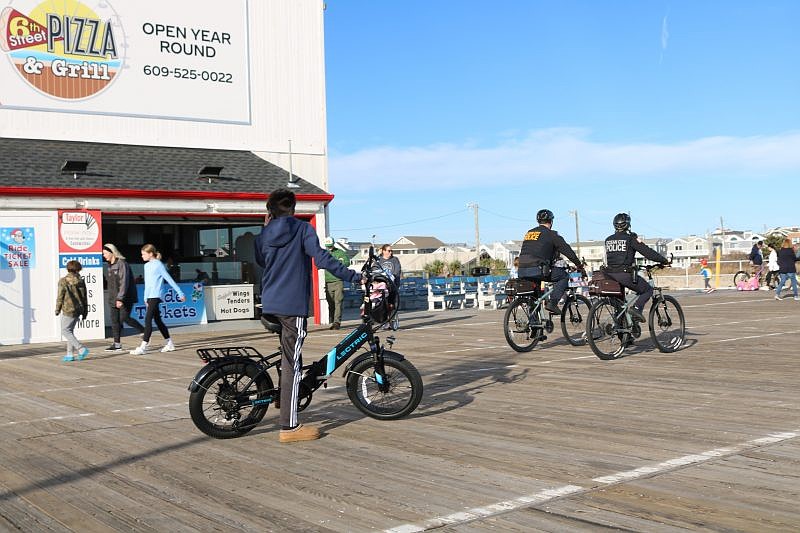 An e-bike rider is passed by Ocean City Police Department bike patrol officers on the Boardwalk.