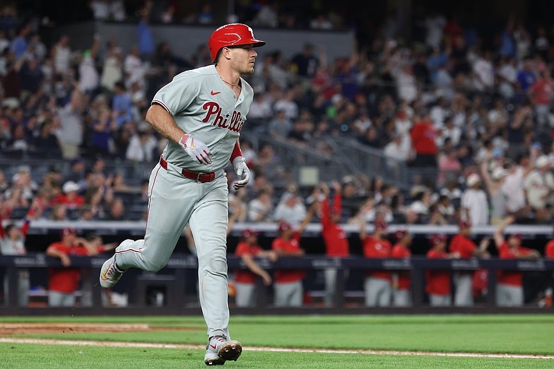 Jul 25, 2025; Bronx, New York, USA; Philadelphia Phillies catcher J.T. Realmuto (10) hits a three run home run during the seventh inning against the New York Yankees at Yankee Stadium. Mandatory Credit: Vincent Carchietta-Imagn Images
