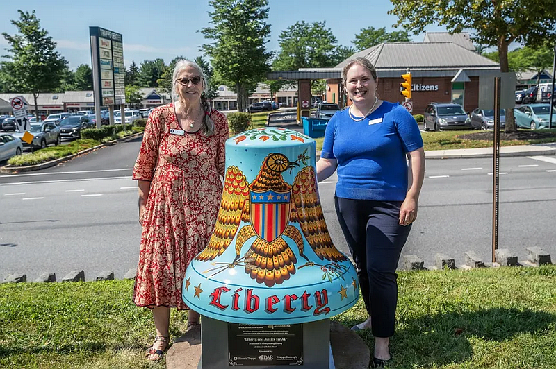Artist Lisa Short, left, and Historic Trappe Executive Director Lisa Minardi are pictured with The Liberty and Justice for All Bell on Aug. 2, 2025 in Trappe. (Photo by Dave Holsten/America250PA)