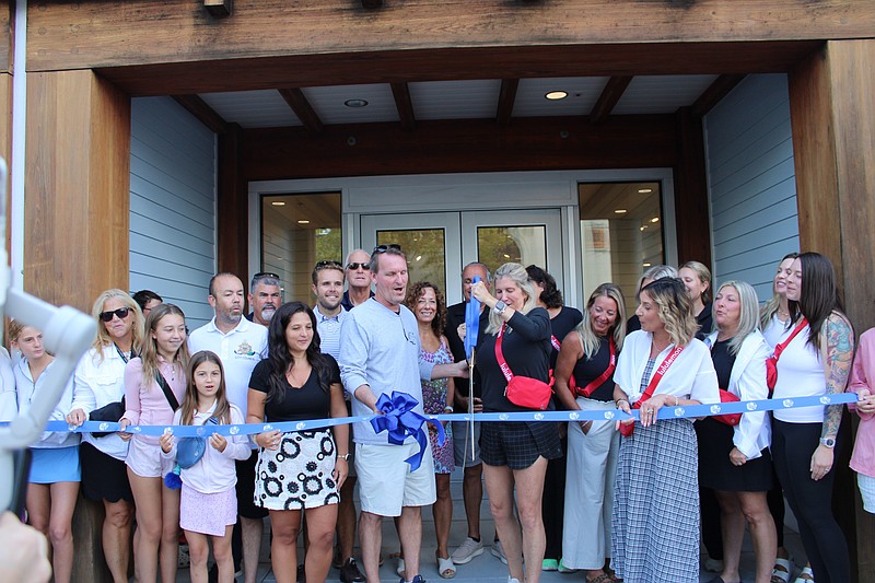 As Mayor Jay Gillian watches, Lululemon store manager Laurie Sykes cuts the ceremonial ribbon for the grand-opening celebration. (Photos courtesy of Ocean City Regional Chamber of Commerce)