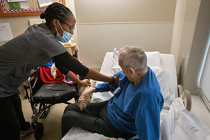 A certified nursing assistant helps a nursing home resident. LevittownNow.com File photo.