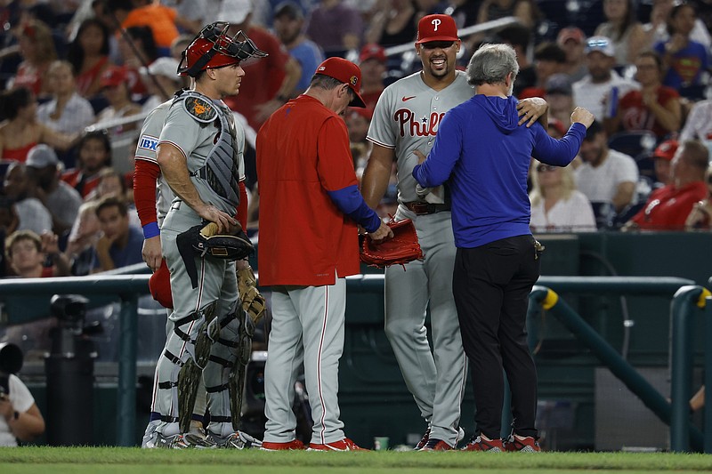 Aug 15, 2025; Washington, District of Columbia, USA; Philadelphia Phillies pitcher Jhoan Duran (59) is assisted by members of the Phillies' training staff after being hit on the leg by a line drive by Washington Nationals third baseman Paul DeJong (not pictured) during the ninth inning at Nationals Park. Mandatory Credit: Geoff Burke-Imagn Images
