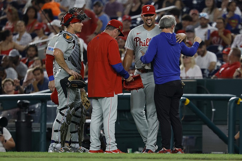 Aug 15, 2025; Washington, District of Columbia, USA; Philadelphia Phillies pitcher Jhoan Duran (59) is assisted by members of the Phillies' training staff after being hit on the leg by a line drive by Washington Nationals third baseman Paul DeJong (not pictured) during the ninth inning at Nationals Park. Mandatory Credit: Geoff Burke-Imagn Images