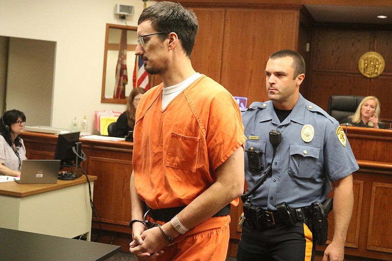 Shackled in handcuffs, Harold Perkins enters the courtroom accompanied by a Cape May County sheriff's officer.
