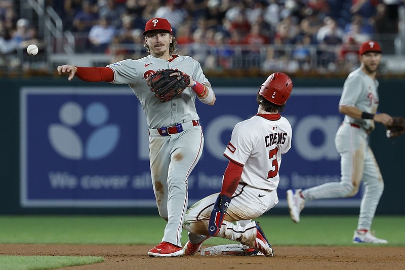 Aug 14, 2025; Washington, District of Columbia, USA; Philadelphia Phillies second baseman Bryson Stott (5) turns a double play at second base ahead of a slide by Washington Nationals outfielder Dylan Crews (3) during the sixth inning at Nationals Park. Mandatory Credit: Geoff Burke-Imagn Images