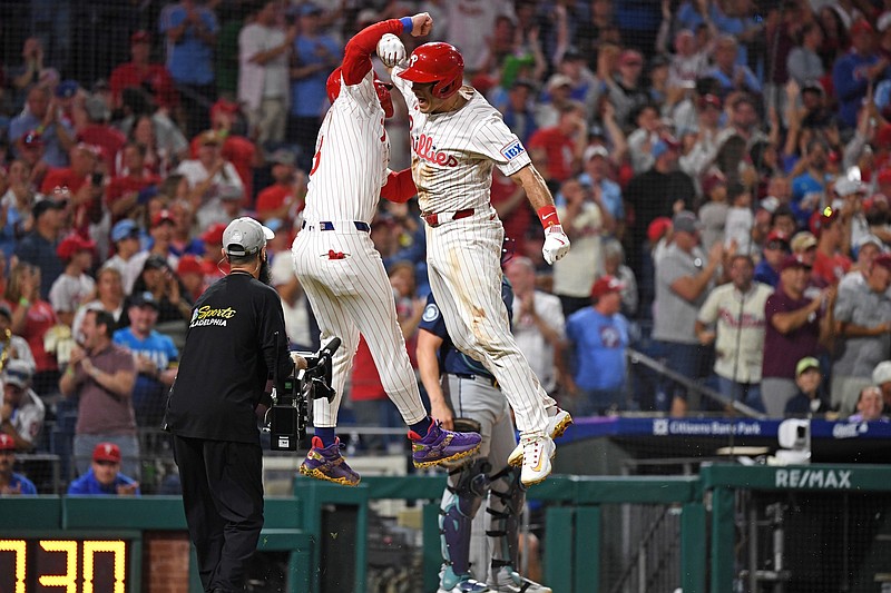 Aug 19, 2025; Philadelphia, Pennsylvania, USA; Philadelphia Phillies catcher J.T. Realmuto (10) celebrates his two-run home run with first base Bryce Harper (3) during the eighth inning against the Seattle Mariners in the dugout at Citizens Bank Park. Mandatory Credit: Eric Hartline-Imagn Images