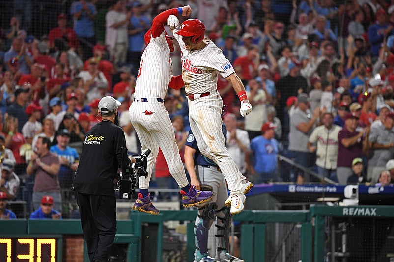 Aug 19, 2025; Philadelphia, Pennsylvania, USA; Philadelphia Phillies catcher J.T. Realmuto (10) celebrates his two-run home run with first base Bryce Harper (3) during the eighth inning against the Seattle Mariners in the dugout at Citizens Bank Park. Mandatory Credit: Eric Hartline-Imagn Images