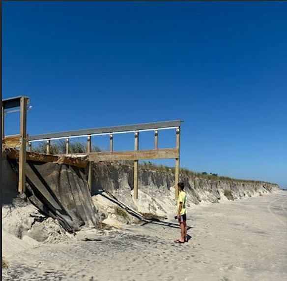 Rocco Palombo, the 13-year-old son of Upper Township Committeeman Zachary Palombo, looks up at the severe beach erosion caused by Hurricane Erin that left cliff-like drop-offs in Strathmere's dunes. (Photo courtesy of Zachary Palombo)
