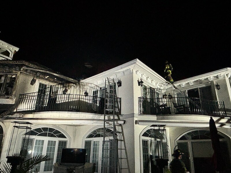 A firefighter stands on the roof of the scorched house on Tobago Lane in Ocean City. (Photos provided)