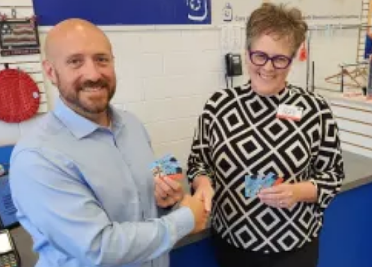 Brandon Trombetta, executive director of Keystone Opportunity Center, accepts a $5,000 donation in gift cards from Sarah Bergin, executive director of Care & Share Thrift Shoppes. (Credit: Keystone Opportunity Center)