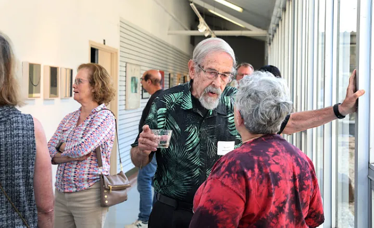 Bruce Katsiff, who chaired Bucks County Community College’s arts department in the 1970s and 80s before becoming the founding director of the Michener Art Museum in Doylestown, chats with Emmi Schatz, whose mother Charlotte Schatz (1929-2023) taught at Bucks for more than 30 years. Katsiff and Charlotte Schatz are among 27 artists whose works are featured in “The Faculty Emeriti Arts Exhibition” through October 25 on the Newtown Campus. (Credit: Mel Evans/Bucks County Community College)
