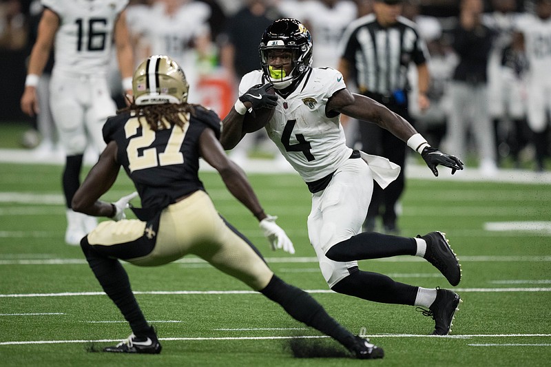Aug 17, 2025; New Orleans, Louisiana, USA;  Jacksonville Jaguars running back Tank Bigsby (4) runs against New Orleans Saints cornerback Isaac Yiadom (27) during the first half at Caesars Superdome. Mandatory Credit: Matthew Hinton-Imagn Images