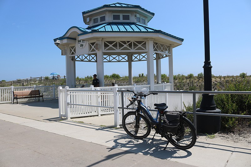 An e-bike is parked on the Sea Isle City Promenade near the gazebo.