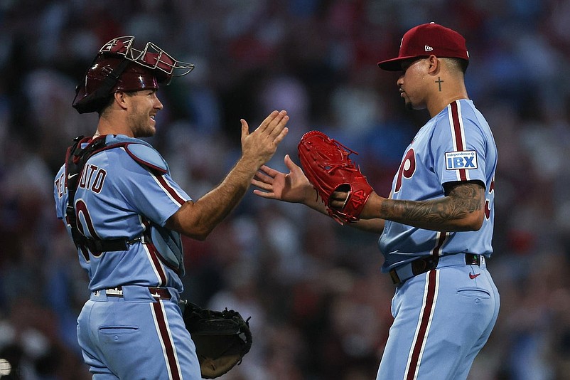 Sep 11, 2025; Philadelphia, Pennsylvania, USA; Philadelphia Phillies pitcher Jhoan Duran (59) and catcher J.T. Realmuto (10) shake hands after a win against the New York Mets at Citizens Bank Park. Mandatory Credit: Bill Streicher-Imagn Images
