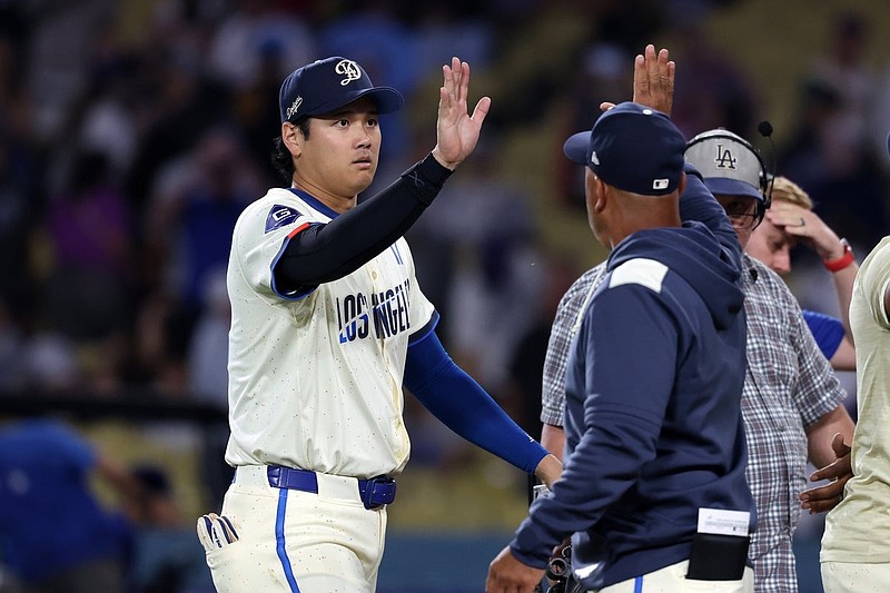 Aug 9, 2025; Los Angeles, California, USA;  Los Angeles Dodgers designated hitter Shohei Ohtani (17) celebrates a win with manager Dave Roberts (30, right) after defeating the Toronto Blue Jays 9-1 at Dodger Stadium. Mandatory Credit: Kiyoshi Mio-Imagn Images
