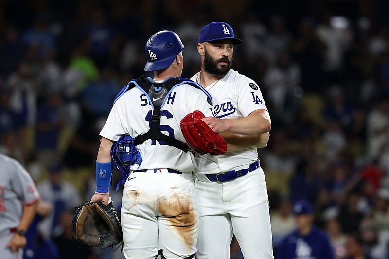 Aug 26, 2025; Los Angeles, California, USA; Los Angeles Dodgers relief pitcher Tanner Scott (66) and catcher Will Smith (16) celebrate a win after defeating the Cincinnati Reds 6-3 at Dodger Stadium. Mandatory Credit: Kiyoshi Mio-Imagn Images