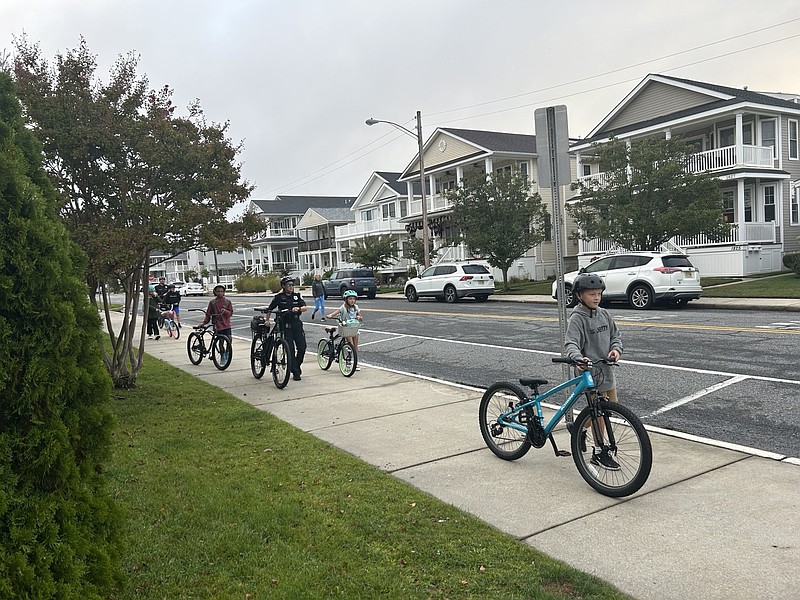 Police officers reinforce bike safety with Ocean City Intermediate School students while heading down a sidewalk. (Photo courtesy of Ocean City school district)