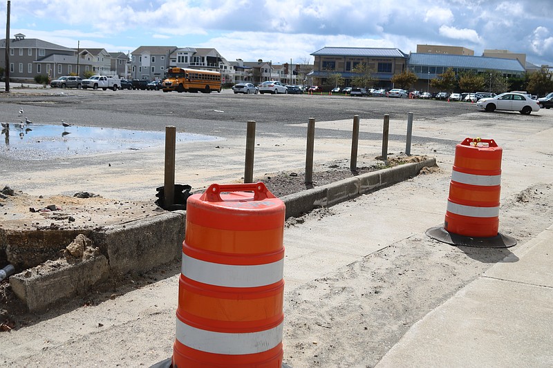 Construction barrels line the sidewalk surrounding the vacant property.