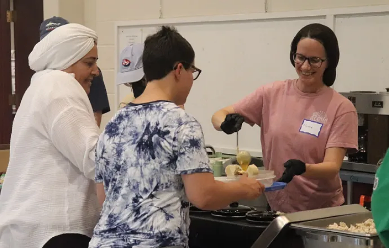 Trinity Lutheran Church volunteers serve complimentary meals to community members as part of the church’s mission to fight food insecurity.