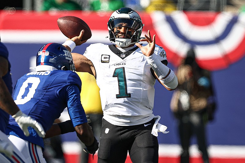Oct 20, 2024; East Rutherford, New Jersey, USA; Philadelphia Eagles quarterback Jalen Hurts (1) throws the ball as New York Giants linebacker Brian Burns (0) pursues during the second half at MetLife Stadium. Mandatory Credit: Vincent Carchietta-Imagn Images
