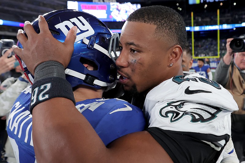 Oct 9, 2025; East Rutherford, New Jersey, USA; New York Giants running back Cam Skattebo (44) hugs Philadelphia Eagles running back Saquon Barkley (26) after their game at MetLife Stadium. Mandatory Credit: Brad Penner-Imagn Images