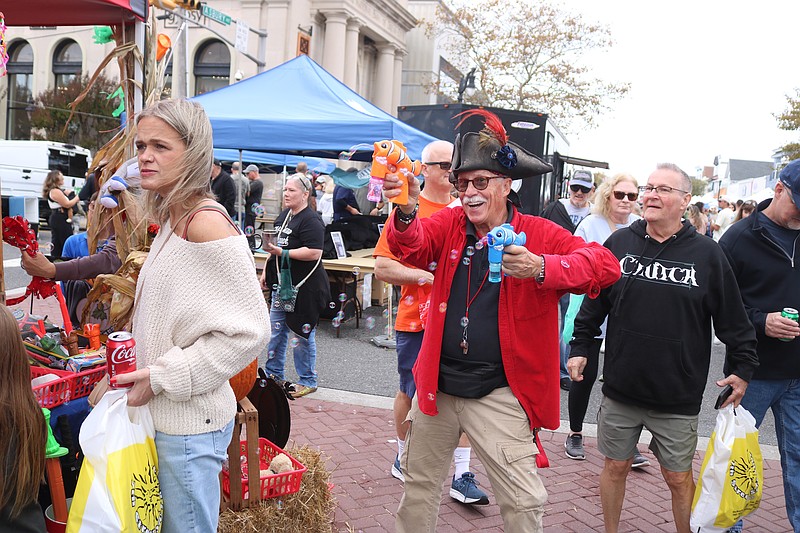 Dressed as a pirate, Air Circus owner Doug Jewell entertains the crowds with a toy that shoots bubbles in the air.