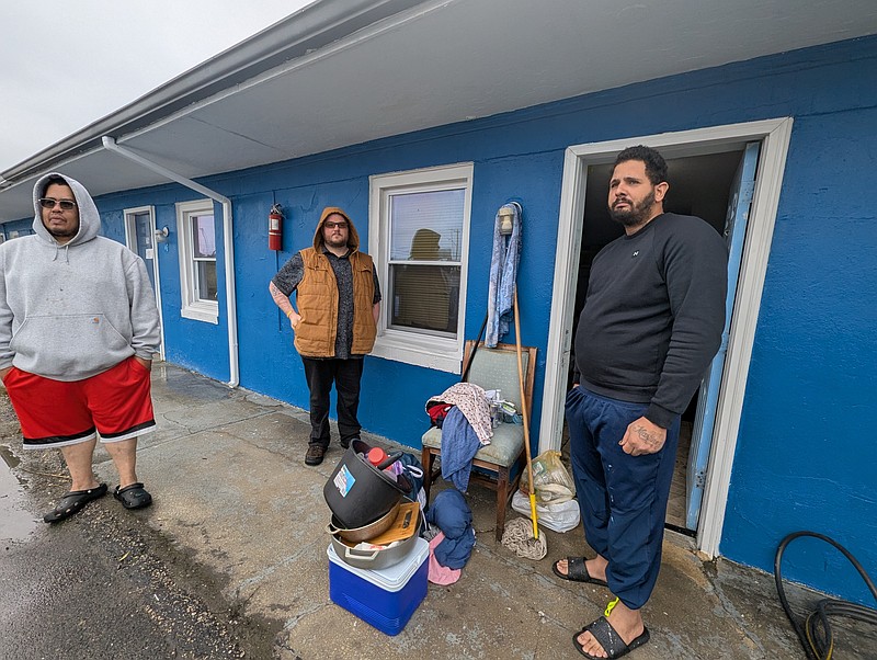 Franklin Quintanilla, Scott Denney and Manny Abrahante talk outside the Travel Inn where they live.