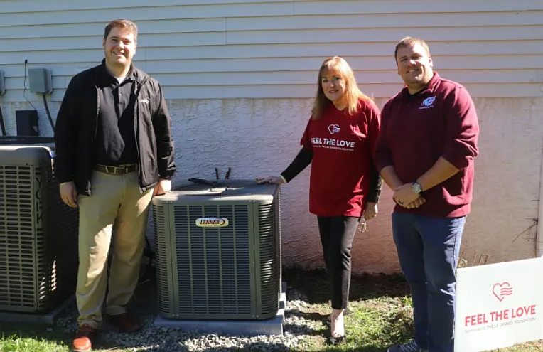Alexandra Rudnitskas poses for a picture with Lennox Territory Manager Luke Galvanoni and C&C Heating and Air Condtioning Managing Director Josh Hill in front of her new HVAC system.