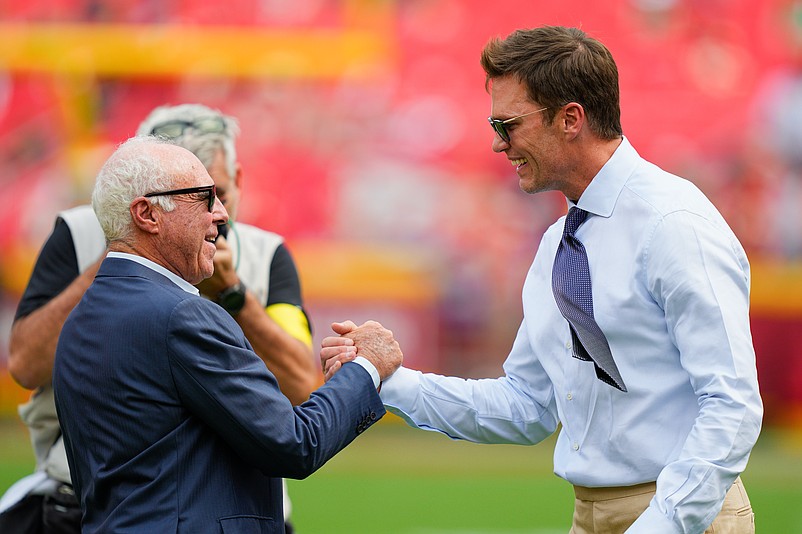 Sep 14, 2025; Kansas City, Missouri, USA; Philadelphia Eagles owner Jeffrey Lurie greets Fox Sports broadcaster Tom Brady prior to the game between the Kansas City Chiefs and the Philadelphia Eagles at GEHA Field at Arrowhead Stadium. Mandatory Credit: Jay Biggerstaff-Imagn Images