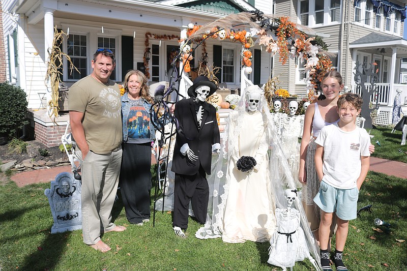 Lou and Woozie Becker and their children, Lynnie and Freddie, pose for a family portrait in their elaborate Halloween skeleton wedding display.