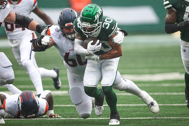 Sep 29, 2024; East Rutherford, New Jersey, USA; New York Jets cornerback Michael Carter II (30) is tackled by Denver Broncos center Luke Wattenberg (60) after recovering a fumble during the first half at MetLife Stadium. Mandatory Credit: Vincent Carchietta-Imagn Images