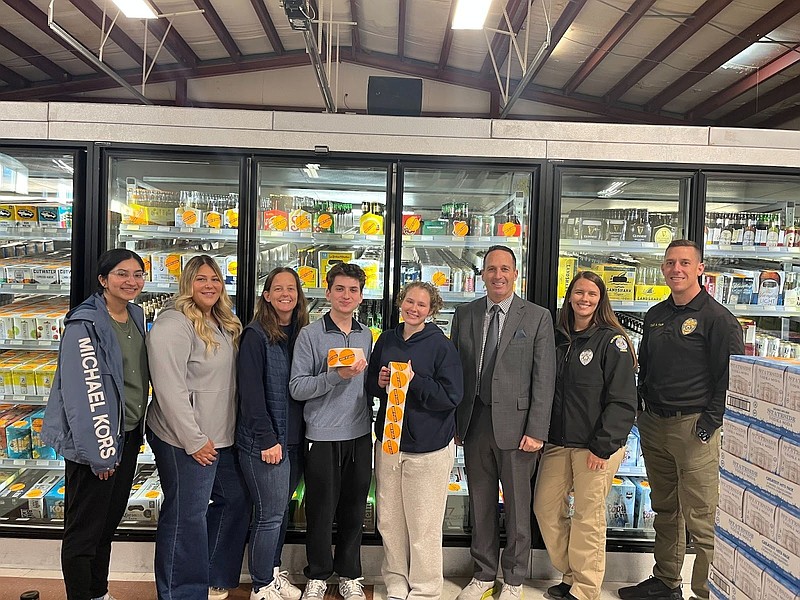 PROVIDED/Members of the Greater Atlantic Partnership and Stand Up and REBEL group with members of the Egg Harbor Township Police Department during the Sticker Shock campaign at Passion Vines in Egg Harbor Township.