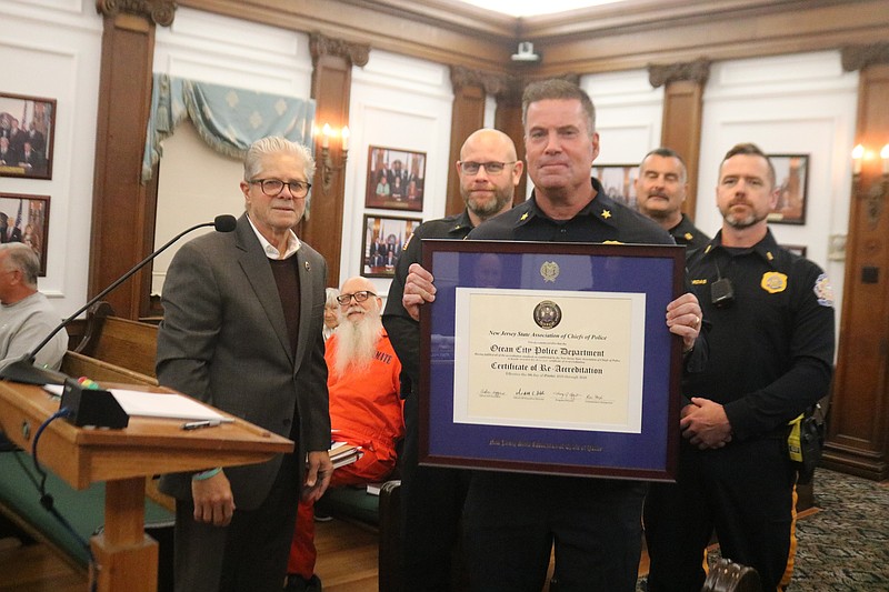 Ocean City Police Chief William Campbell holds the re-accreditation award presented to him by Harry Delgado, left, of the New Jersey State Association of Chiefs of Police.