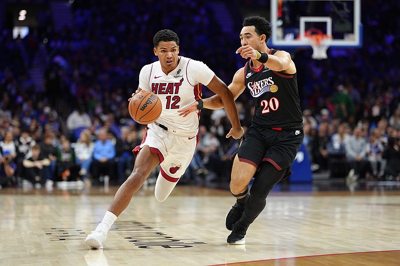 Nov 23, 2025; Philadelphia, Pennsylvania, USA; Miami Heat guard Dru Smith (12) drives against Philadelphia 76ers guard Jared McCain (20) in the first quarter at Xfinity Mobile Arena. Mandatory Credit: Kyle Ross-Imagn Images