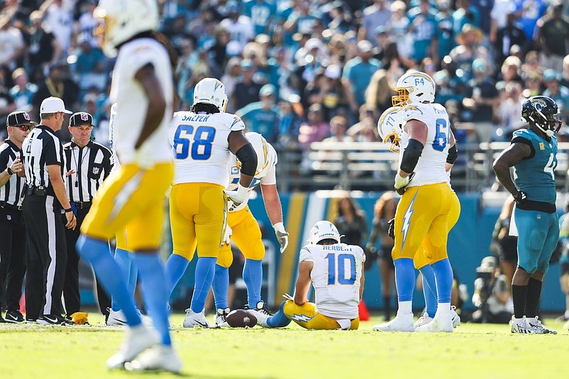 Nov 16, 2025; Jacksonville, Florida, USA; Los Angeles Chargers quarterback Justin Herbert (10) sits on the turf following a fourth down play against the Jacksonville Jaguars during the second quarter at EverBank Stadium. Mandatory Credit: Morgan Tencza-Imagn Images