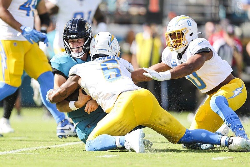 Nov 16, 2025; Jacksonville, Florida, USA; Los Angeles Chargers linebacker Denzel Perryman (6) tackles Jacksonville Jaguars quarterback Trevor Lawrence (16) during the first quarter at EverBank Stadium. Los Angeles Chargers linebacker Daiyan Henley (0) follows up on the play at right. Mandatory Credit: Morgan Tencza-Imagn Images