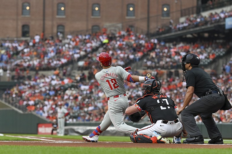Jun 14, 2024; Baltimore, Maryland, USA;  Philadelphia Phillies designated hitter Kyle Schwarber (12) hits a solo home run in the first inning against the Baltimore Orioles at Oriole Park at Camden Yards. Mandatory Credit: Tommy Gilligan-USA TODAY Sports