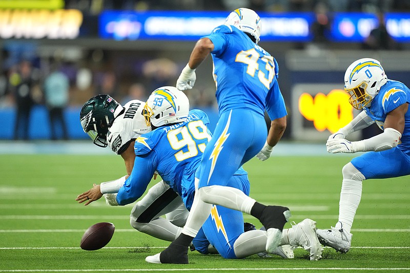 Dec 8, 2025; Inglewood, California, USA; Los Angeles Chargers defensive tackle Jamaree Caldwell (99) tackles Philadelphia Eagles quarterback Jalen Hurts (1) in the first half at SoFi Stadium. Mandatory Credit: Kirby Lee-Imagn Images