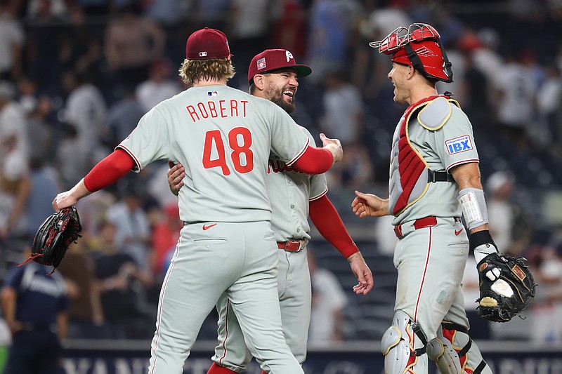 Jul 25, 2025; Bronx, New York, USA; Philadelphia Phillies relief pitcher Daniel Robert (48) and designated hitter Kyle Schwarber (12) and catcher J.T. Realmuto (10) celebrates after the game against the New York Yankees at Yankee Stadium. Mandatory Credit: Vincent Carchietta-Imagn Images