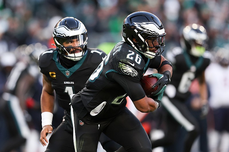 Nov 28, 2025; Philadelphia, Pennsylvania, USA; Philadelphia Eagles quarterback Jalen Hurts (1) hands the ball to Philadelphia Eagles running back Saquon Barkley (26) against the Chicago Bears during the second quarter of the game at Lincoln Financial Field. Mandatory Credit: Bill Streicher-Imagn Images