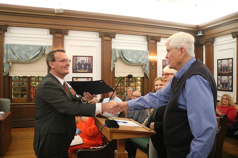 Ocean City Mayor Jay Gillian shakes hands with Bill Elliott while handing him the city proclamation.
